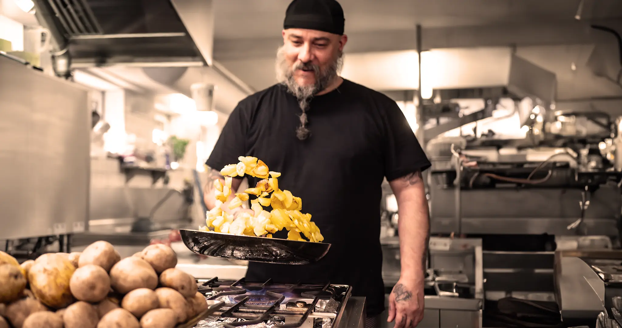 Koch beim Zubereiten von Bratkartoffeln