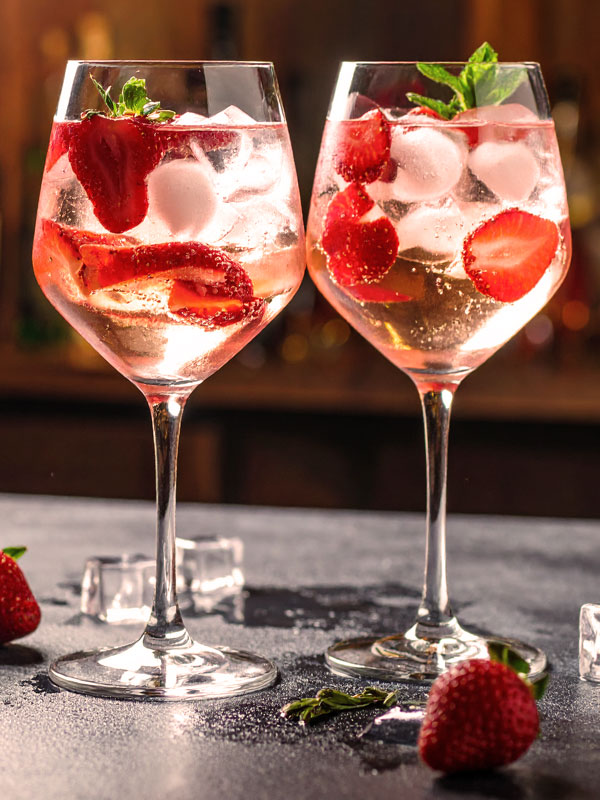 2 Gläser mit Prosecco, frischen Erdbeeren und Minzblatt